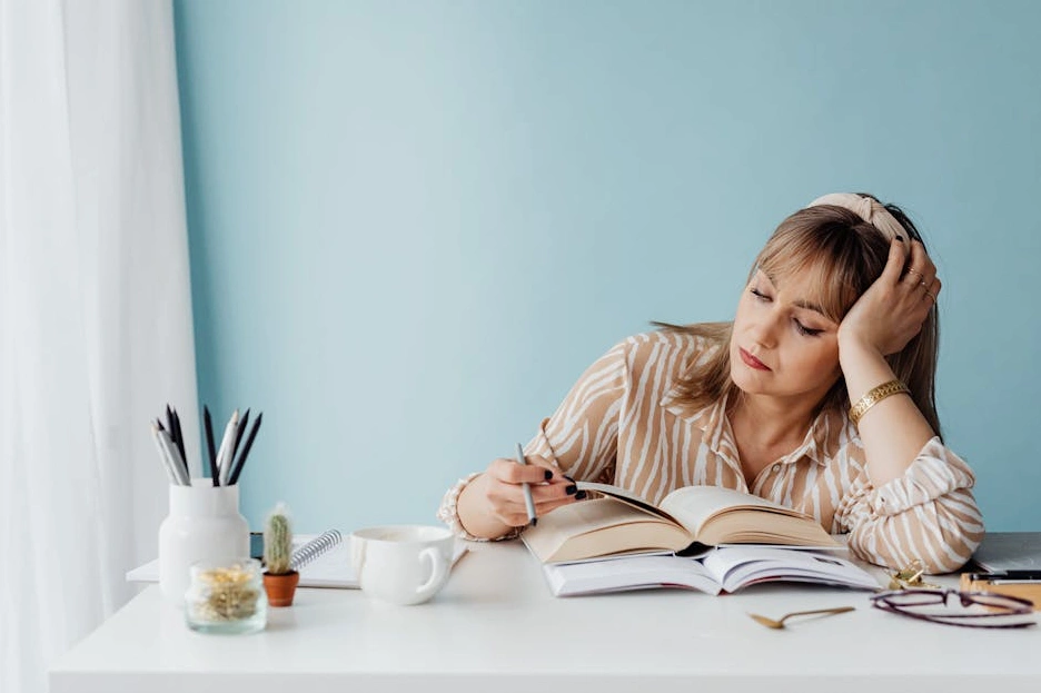 Osoba si zapisuje cíle a plány do elegantního poznámkového bloku.